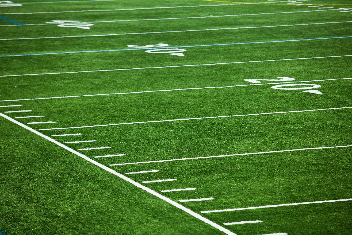 A close-up view of a green American football field in Salt Lake City, showing white yard lines and numbers marking 20, 30, and 40 yards, with clear boundary lines and hash marks on the artificial turf installation.