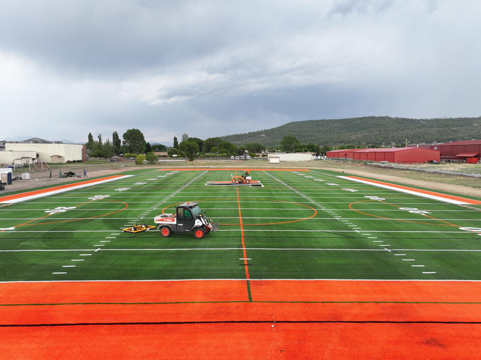 A close-up view of a green American football field in Salt Lake City, showing white yard lines and numbers marking 20, 30, and 40 yards, with clear boundary lines and hash marks on the artificial turf installation.